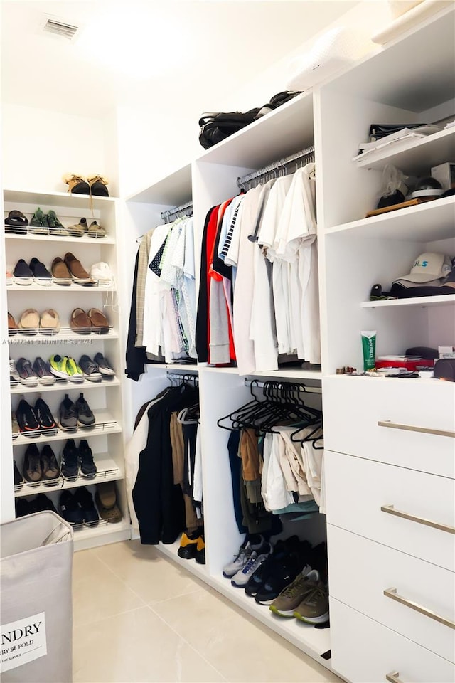 walk in closet with light tile patterned floors