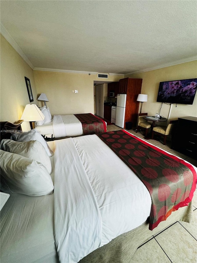 bedroom featuring ornamental molding, a textured ceiling, and white fridge