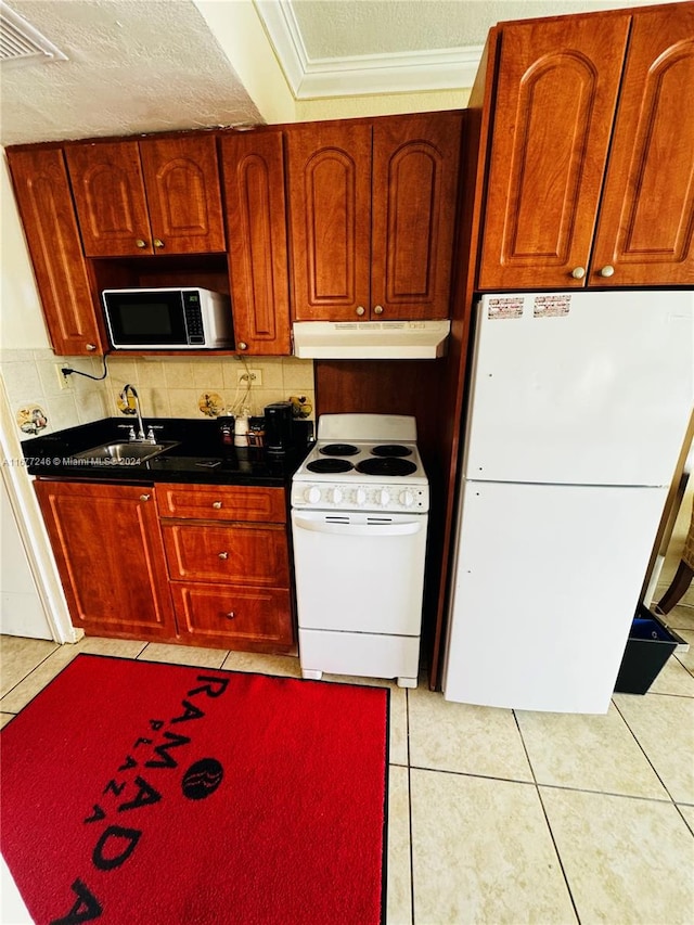 kitchen featuring white appliances, tasteful backsplash, light tile patterned floors, and sink