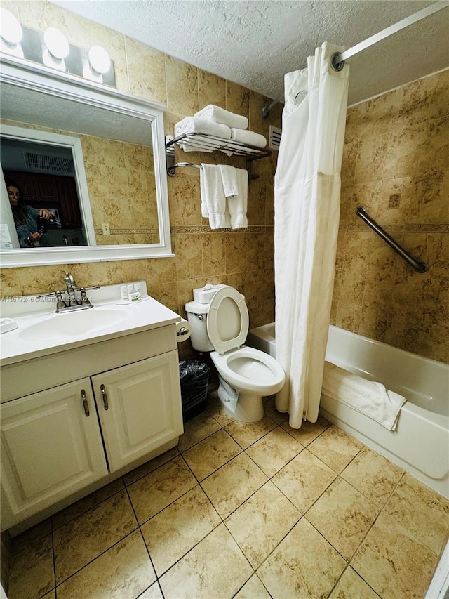 full bathroom featuring a textured ceiling, shower / bath combo, toilet, tile walls, and vanity