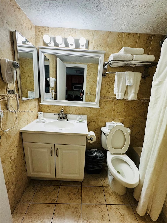 full bathroom featuring toilet, a textured ceiling, and tile walls