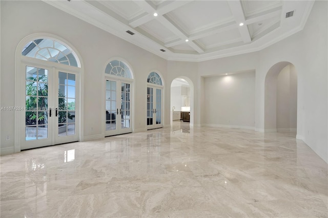 unfurnished room with beam ceiling, french doors, coffered ceiling, a towering ceiling, and ornamental molding