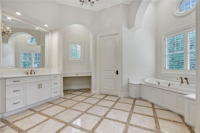 bathroom featuring vanity, ornamental molding, a tub, and a chandelier