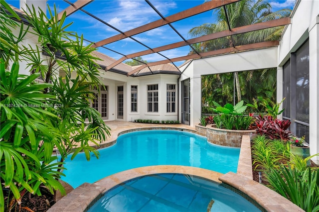 view of swimming pool featuring a lanai and an in ground hot tub