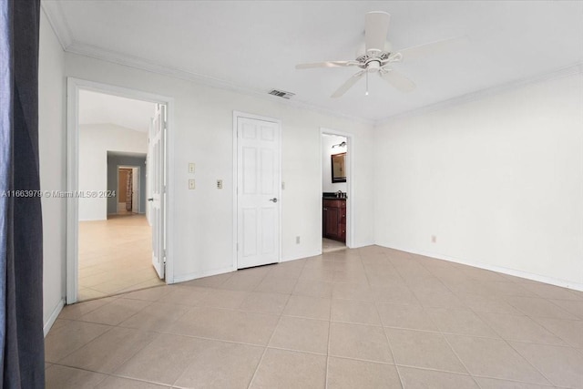 spare room featuring ceiling fan, light tile patterned floors, crown molding, and vaulted ceiling