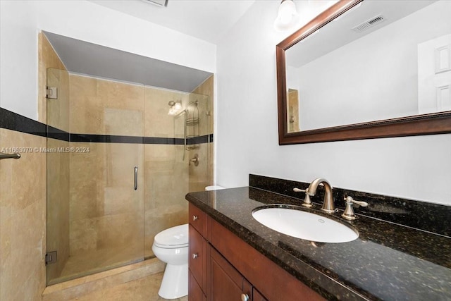 bathroom featuring tile patterned floors, vanity, toilet, and an enclosed shower