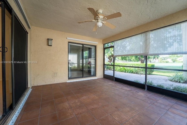 unfurnished sunroom with ceiling fan