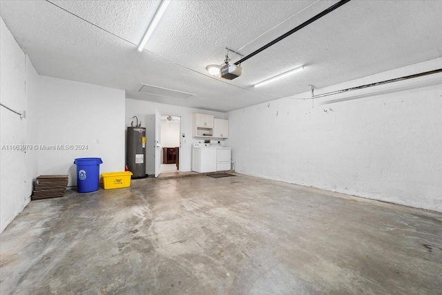 garage featuring electric water heater, separate washer and dryer, and a garage door opener