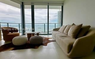 living room with a water view and a wall of windows