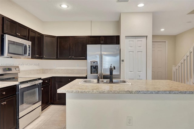 kitchen with sink, dark brown cabinetry, appliances with stainless steel finishes, and a center island