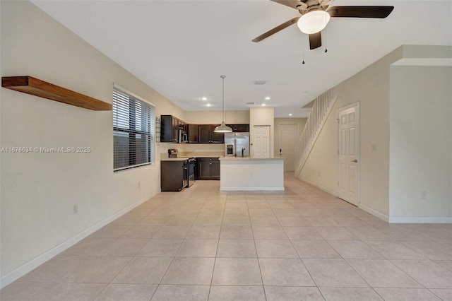 kitchen featuring ceiling fan, a center island, stainless steel appliances, and light tile patterned flooring