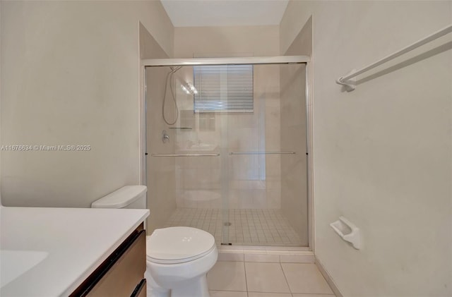 bathroom with an enclosed shower, vanity, tile patterned flooring, and toilet