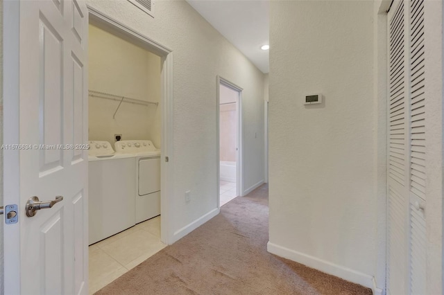 hallway featuring light carpet and washing machine and clothes dryer