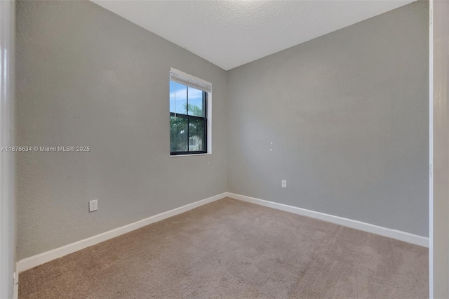 carpeted spare room featuring a textured ceiling