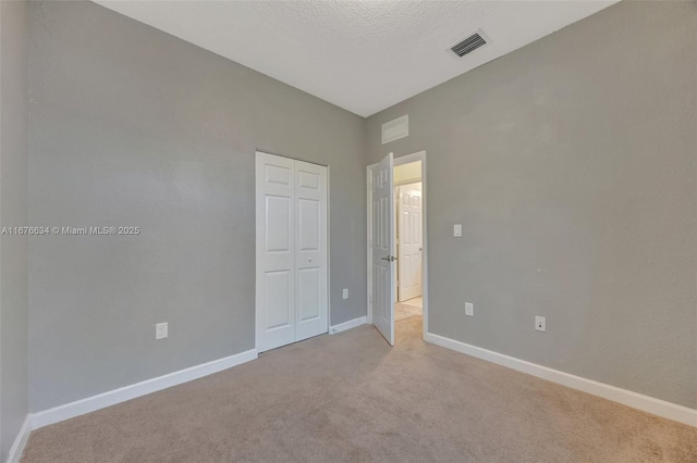 carpeted spare room with a textured ceiling