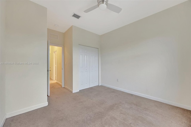 unfurnished bedroom with ceiling fan, a closet, and light colored carpet