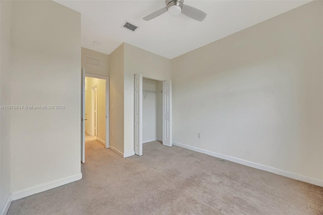 unfurnished bedroom featuring ceiling fan, light colored carpet, and a closet