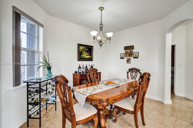 dining space with a notable chandelier and light tile patterned flooring