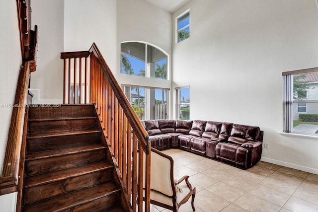 living room featuring a towering ceiling and light tile patterned floors