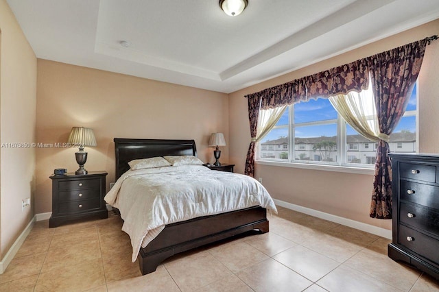 tiled bedroom with a tray ceiling