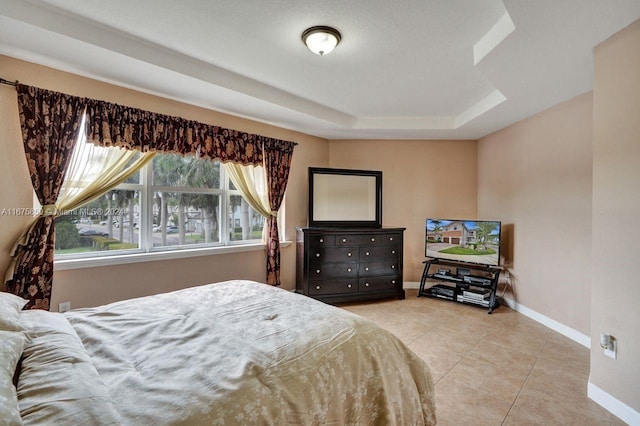 tiled bedroom with a tray ceiling