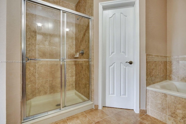 bathroom with shower with separate bathtub and tile patterned flooring