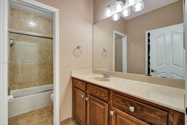 full bathroom with vanity, toilet, tile patterned flooring, and bath / shower combo with glass door