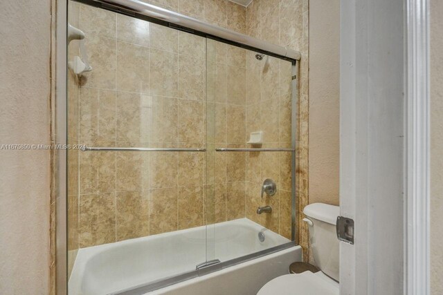 bathroom featuring toilet and enclosed tub / shower combo