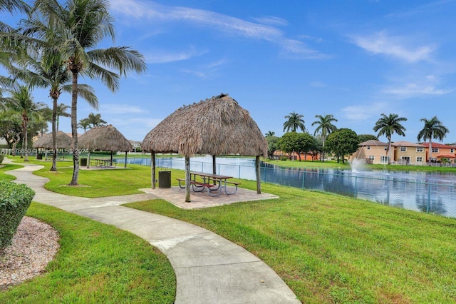 view of home's community with a water view, a gazebo, and a yard