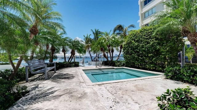 view of pool with a patio area and a water view