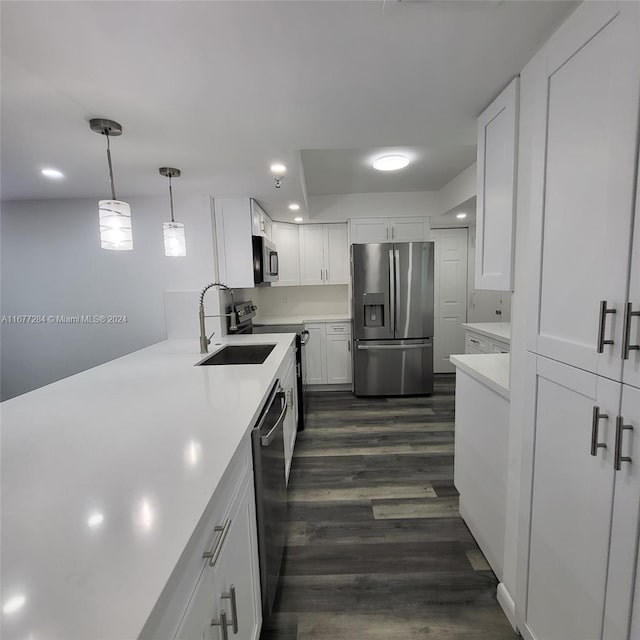 kitchen featuring sink, appliances with stainless steel finishes, pendant lighting, and white cabinets