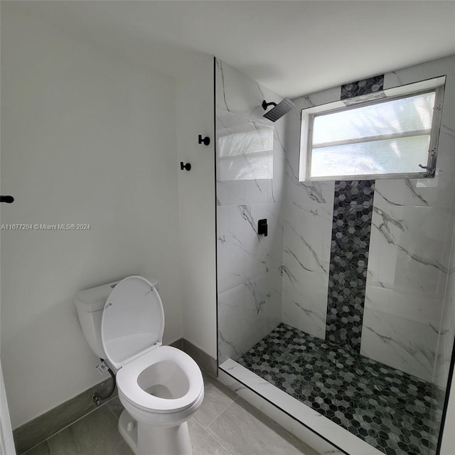 bathroom featuring toilet, tile patterned flooring, and tiled shower