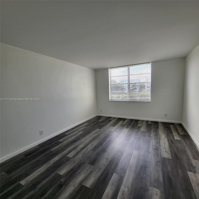 unfurnished room featuring dark wood-type flooring