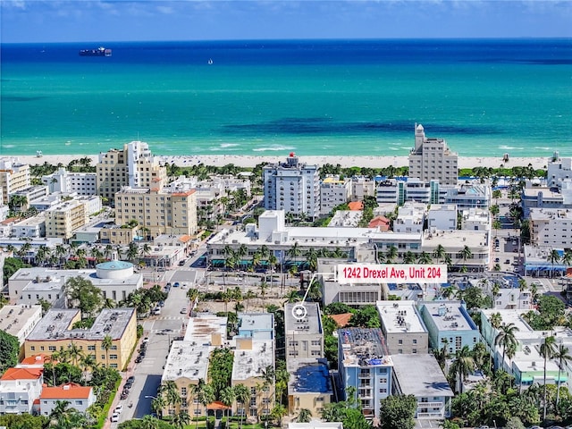 drone / aerial view featuring a water view and a beach view