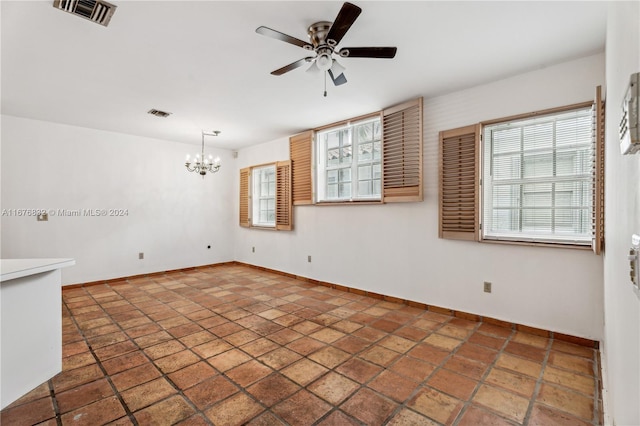 unfurnished room with ceiling fan with notable chandelier