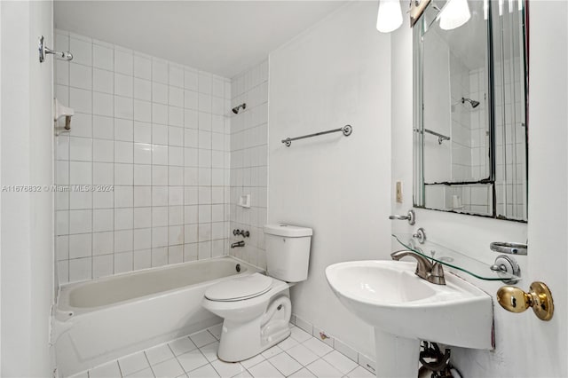 bathroom with toilet, tile patterned flooring, and tiled shower / bath