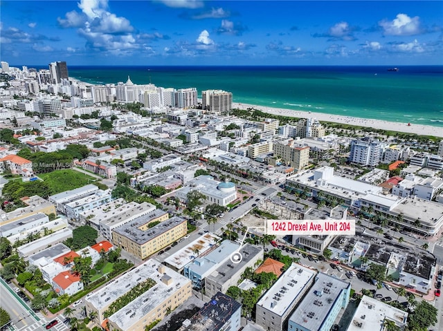 drone / aerial view featuring a water view and a beach view