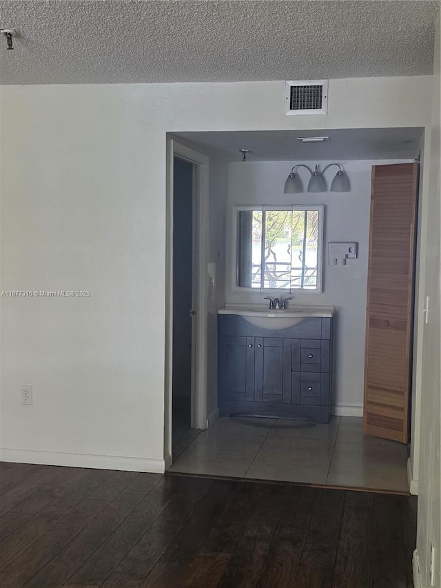661 NE 195th St Unit 215, Miami, FL 33179 - bathroom with a textured ceiling, wood finished floors, and vanity