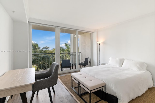 bedroom with wood-type flooring, floor to ceiling windows, and access to exterior