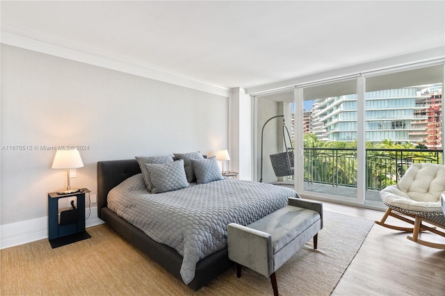 bedroom with crown molding, access to exterior, and light hardwood / wood-style floors