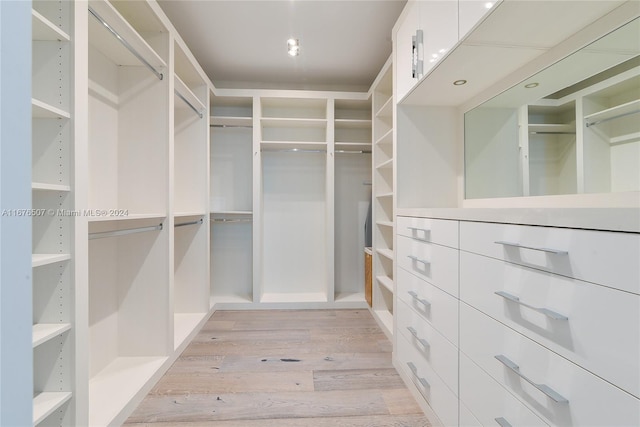 walk in closet with light hardwood / wood-style flooring