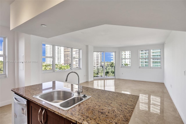 kitchen featuring a center island with sink, stainless steel dishwasher, sink, and plenty of natural light