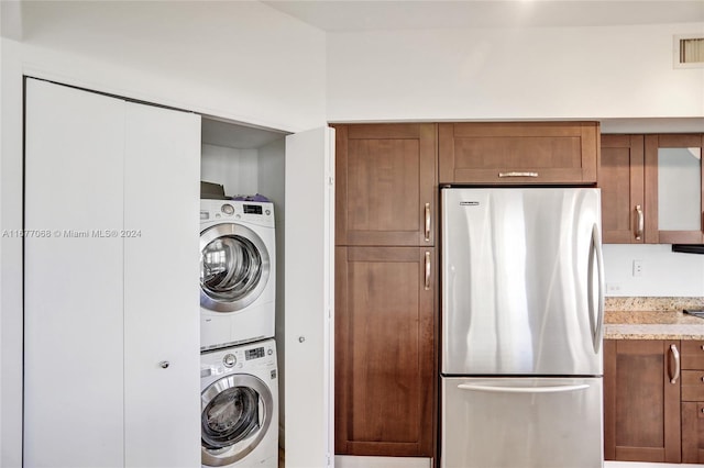 laundry area featuring stacked washing maching and dryer