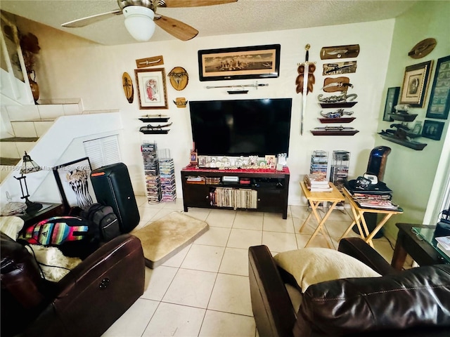 living room featuring ceiling fan, light tile patterned floors, and a textured ceiling