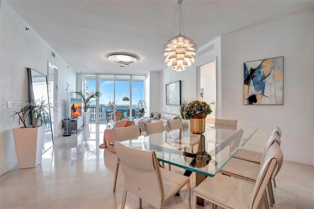 dining space featuring a wall of windows, an inviting chandelier, and light tile patterned floors