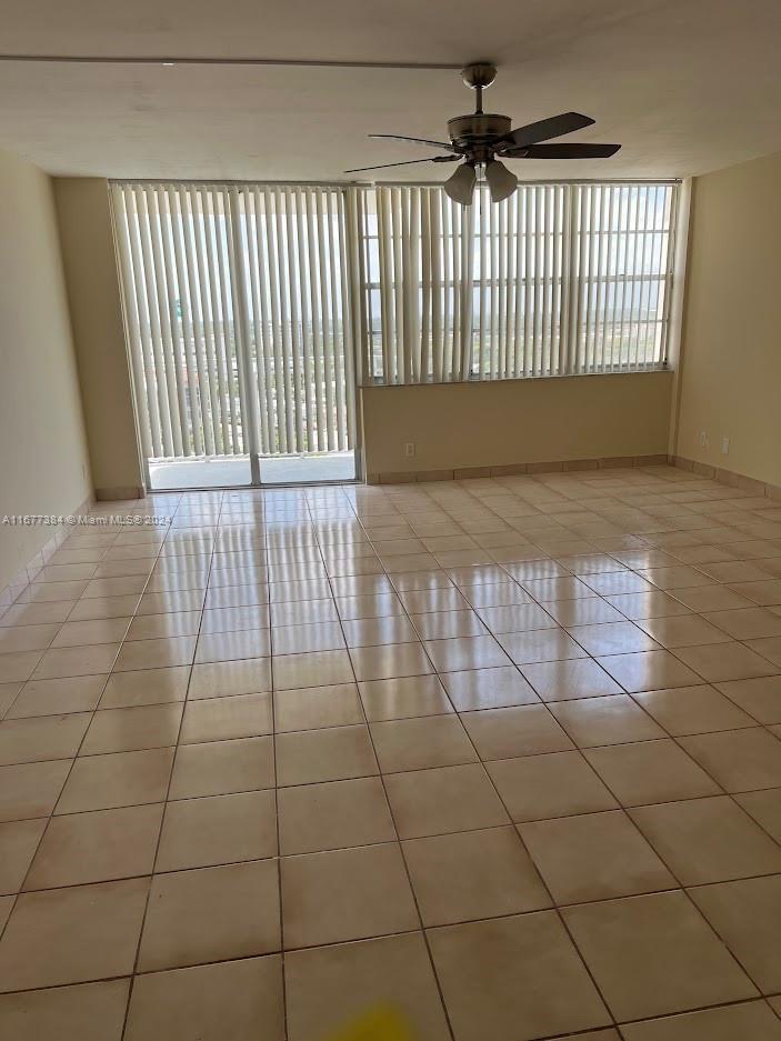 tiled spare room featuring ceiling fan