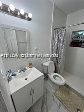 bathroom with toilet, walk in shower, and vanity