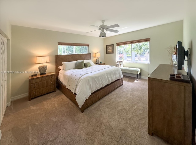 bedroom featuring light colored carpet and ceiling fan