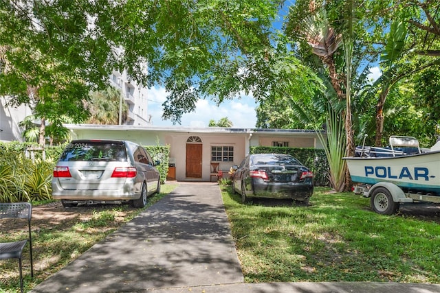 view of front of house with a carport and a front yard