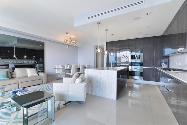 living room featuring sink, a notable chandelier, and light tile patterned floors